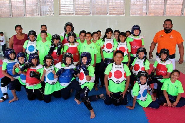 Parte del grupo de niños que practican taekwondo, junto a un instructor y una de las madres. Su alegría prueba que los cambios en los empinados barrios marginales de Tegucigalpa son posibles, si se invierte en dignificarlos. Crédito: Thelma Mejía/IPS
